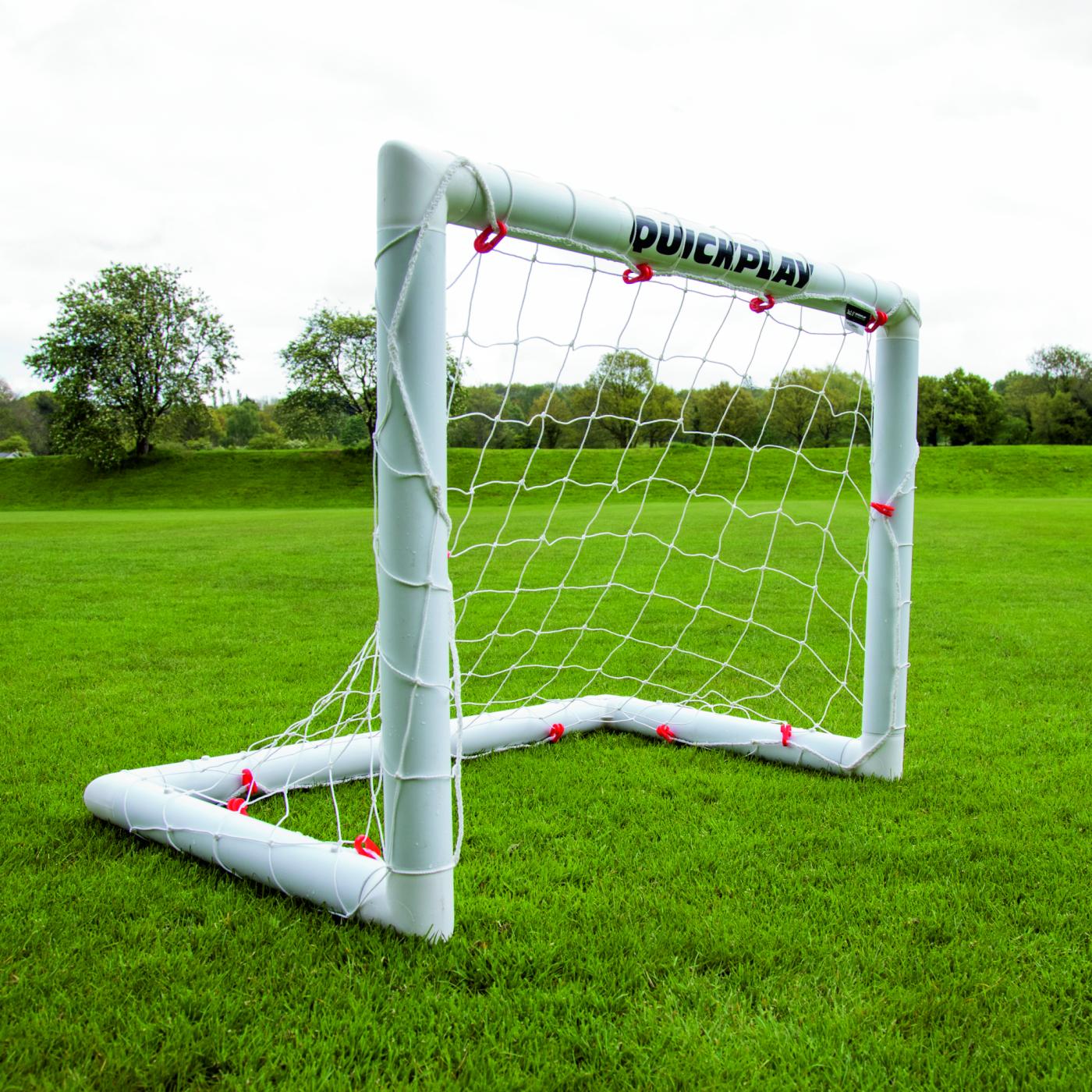 Miniportería de fútbol Q-FOLD 90 x 75 cm en un campo de hierba, vista desde una esquina delantera.