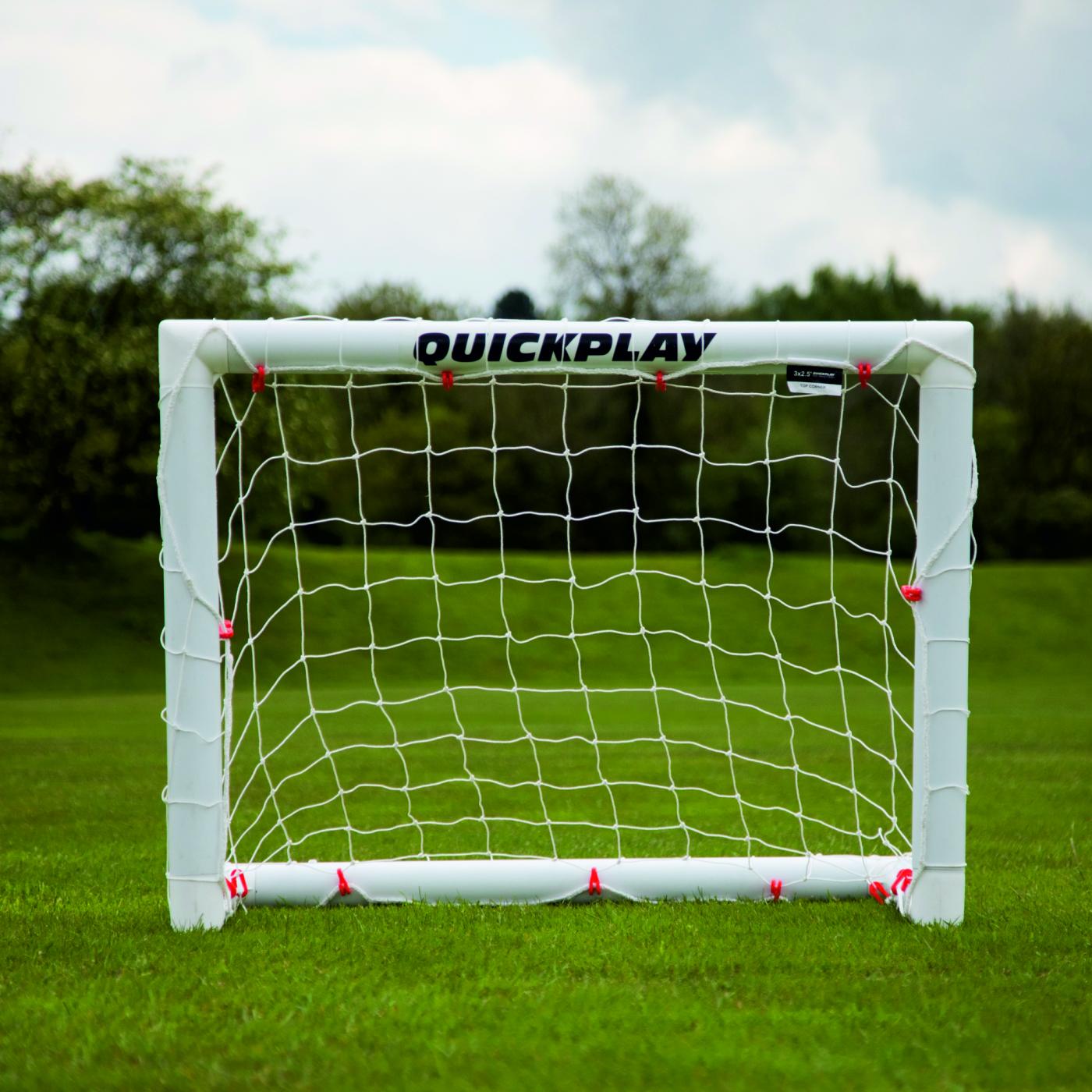 Miniportería de fútbol Q-FOLD 90 x 75 cm vista de frente sobre hierba, con QUICKPLAY en el larguero blanco.