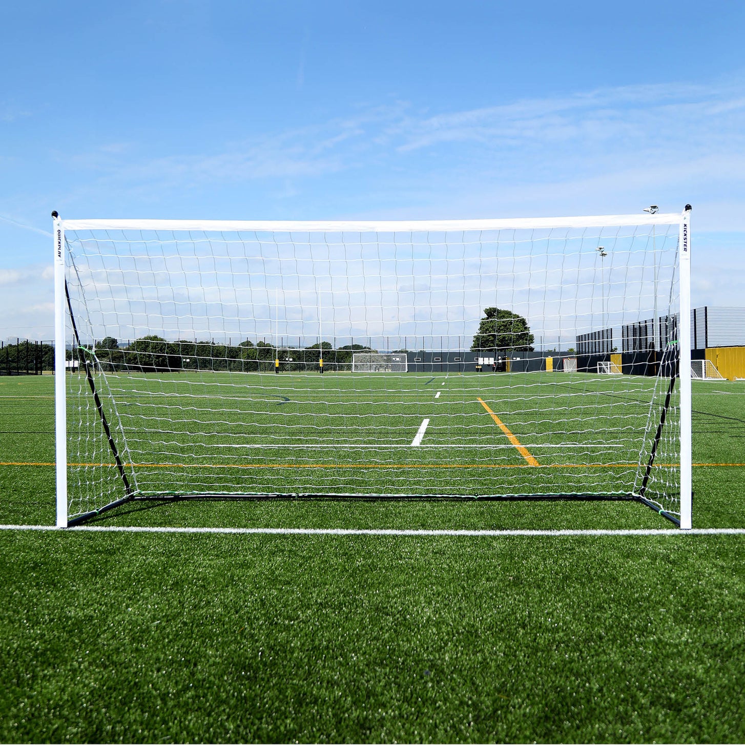 Portería KICKSTER Elite 370 x 180 cm vista de frente en un campo de césped artificial, marco blanco y red blanca.