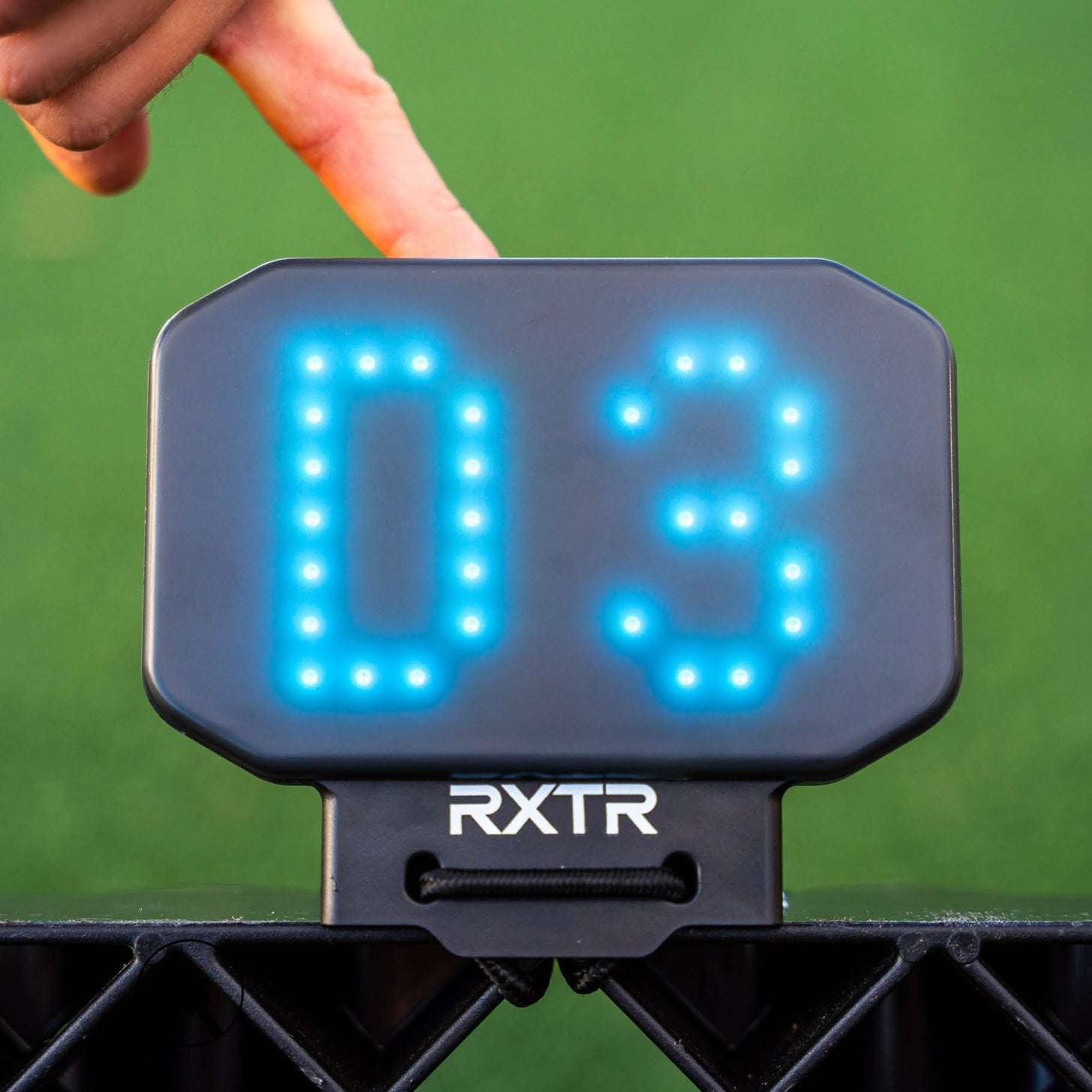 Primer plano de la luz de reacción RXTR que muestra D3 en azul, con un dedo a punto de tocarla.