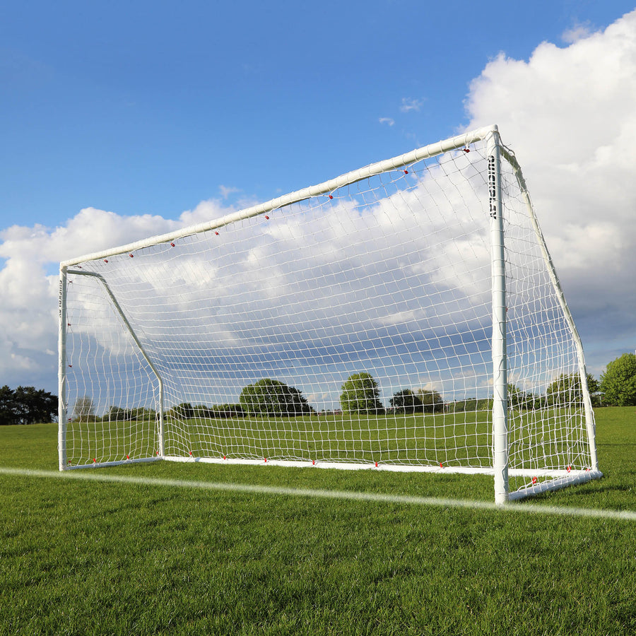 Portería de fútbol plegable Q-FOLD Match 370 x 180 cm con marco y red blancos, sobre hierba bajo un cielo azul con nubes.
